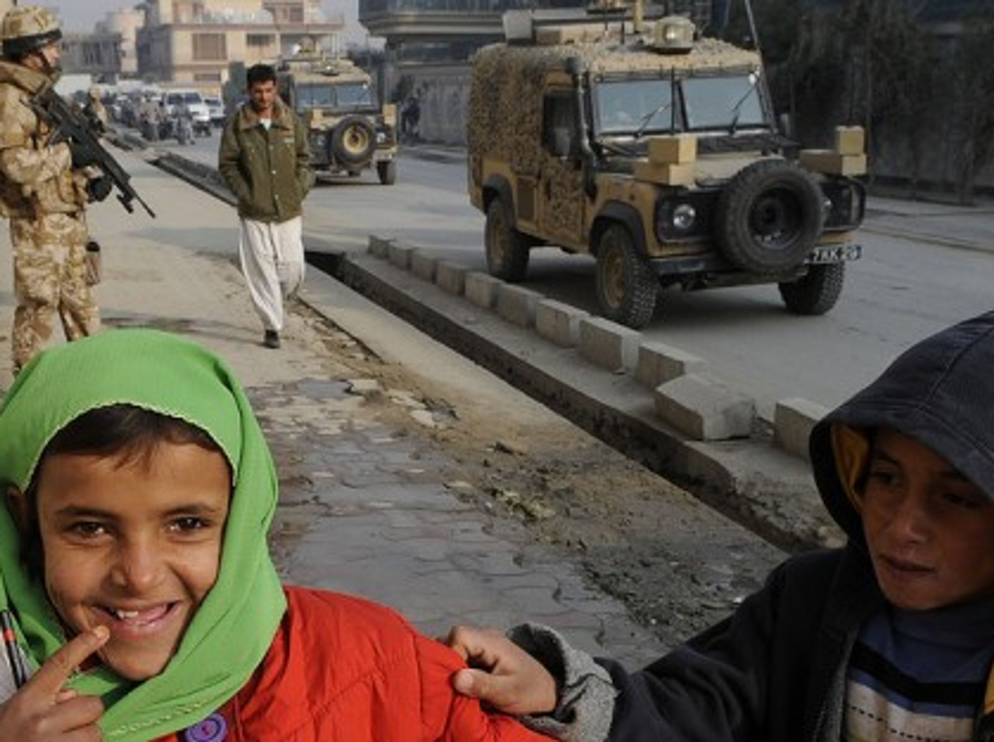 In Kabul, children play as British military vehicles pass (isafmedia)