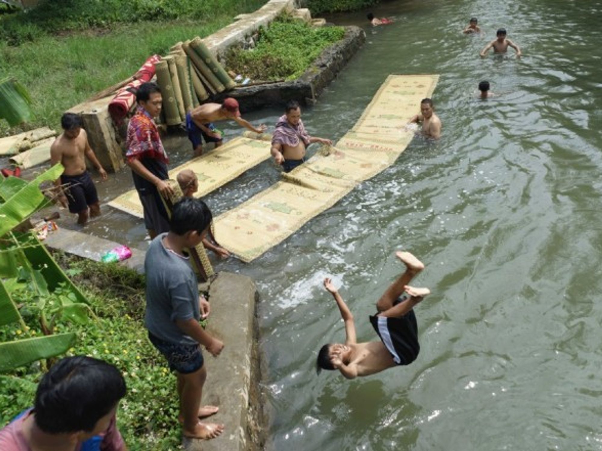 In Semarang, Indonesia, residents wash mosque prayer mats (and have some fun) in a river to purify them, a tradition in preparation for the Ramadan fasting month that will start tomorrow.