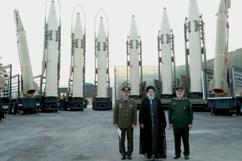 Iranian President EBRAHIM RAISI (C) standing in front of the new Iranian long-range ballistic missiles during the joining ceremony of ballistic missiles to Iranian Armed forces as his Defense Minister MOHAMMAD REZA GHARAEI ASHTIANI (L) and head of the Revolutionary Guard's aerospace division General AMIR ALI HAJIZADEH (2R), accompanies him.