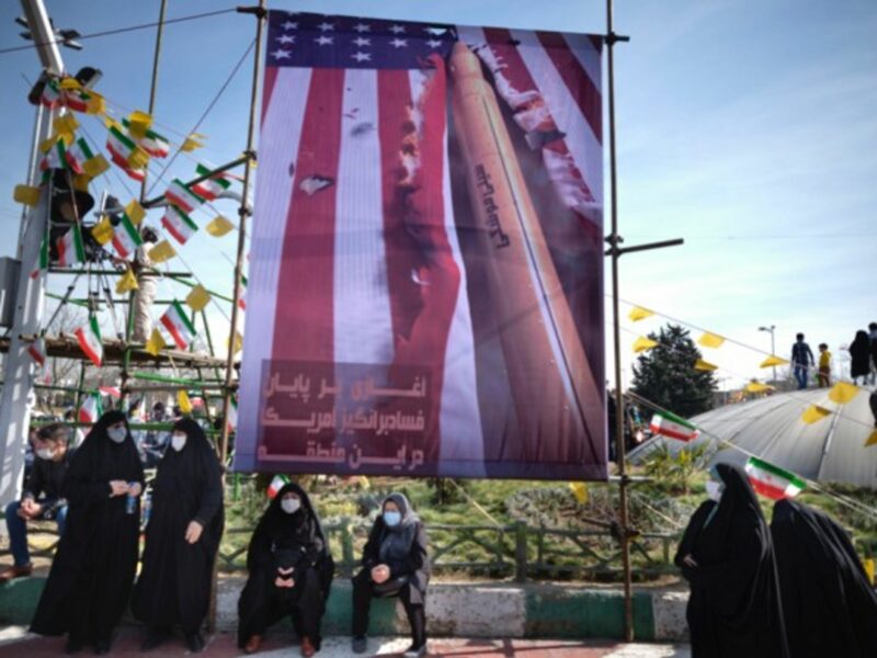 Iranian women under an anti-U.S. banner in Tehran