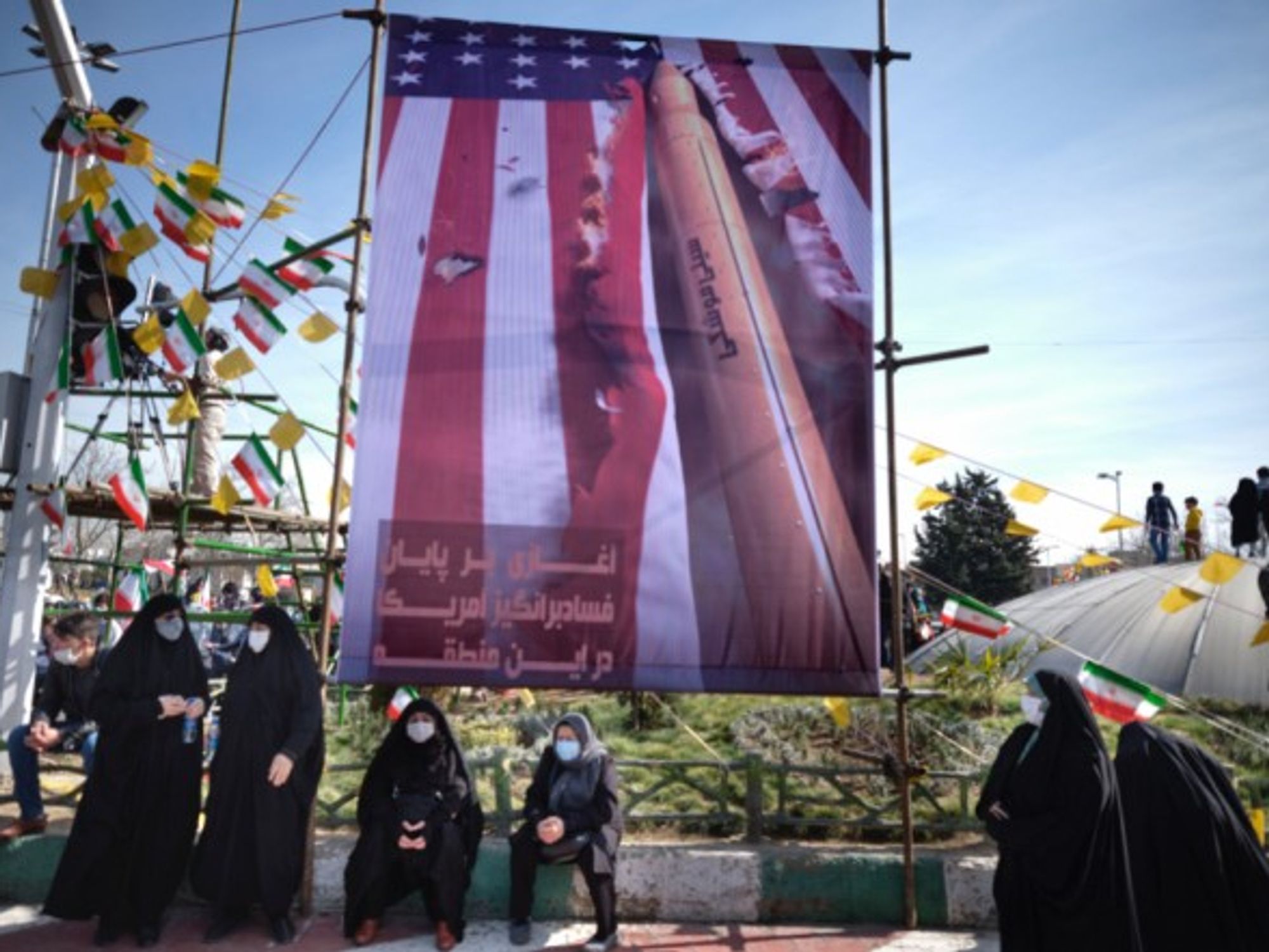 Iranian women under an anti-U.S. banner in Tehran