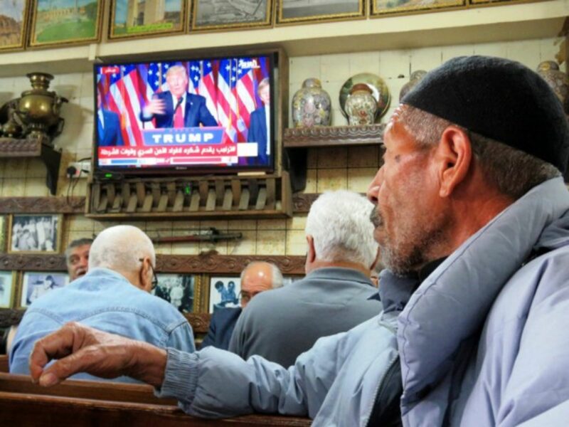 Iraqi men in Baghdad watch television as the newly elected American president speaks.
