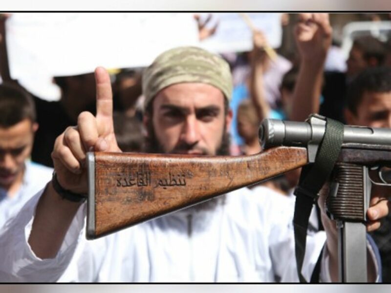 ISIL fighter shows his AK-47 rifle bearing Arabic mention of allegiance to al-Qaeda