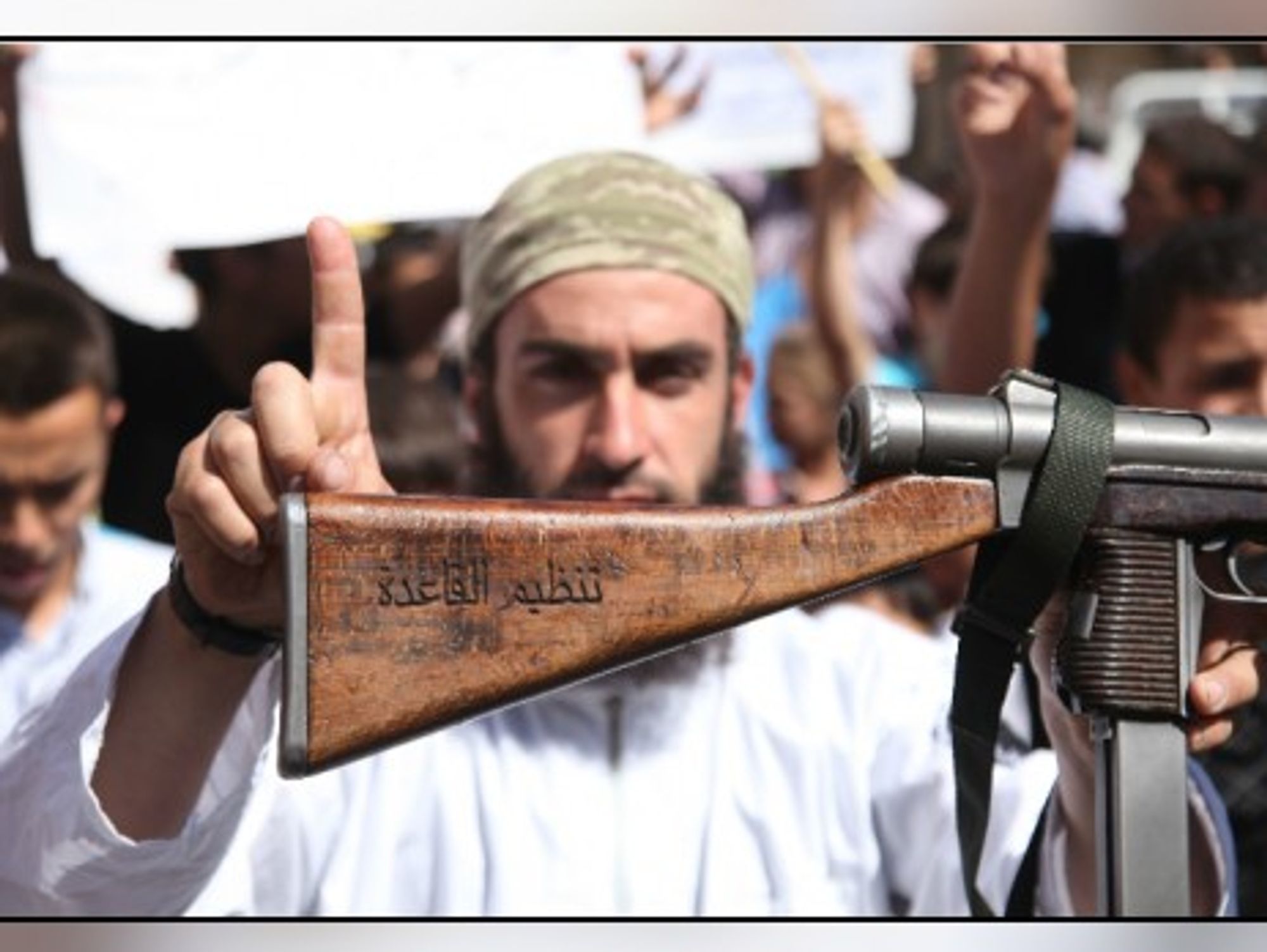 ISIL fighter shows his AK-47 rifle bearing Arabic mention of allegiance to al-Qaeda