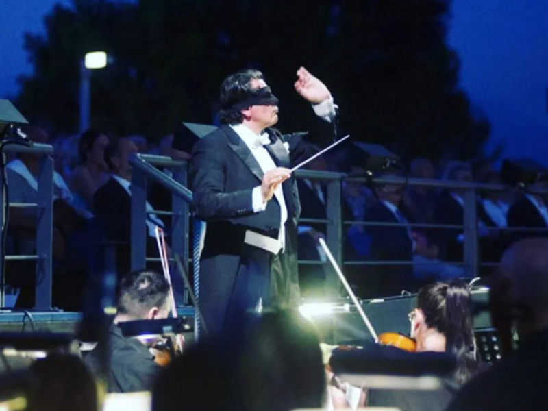 Italian Maestro conducting an orchestra blindfolded.