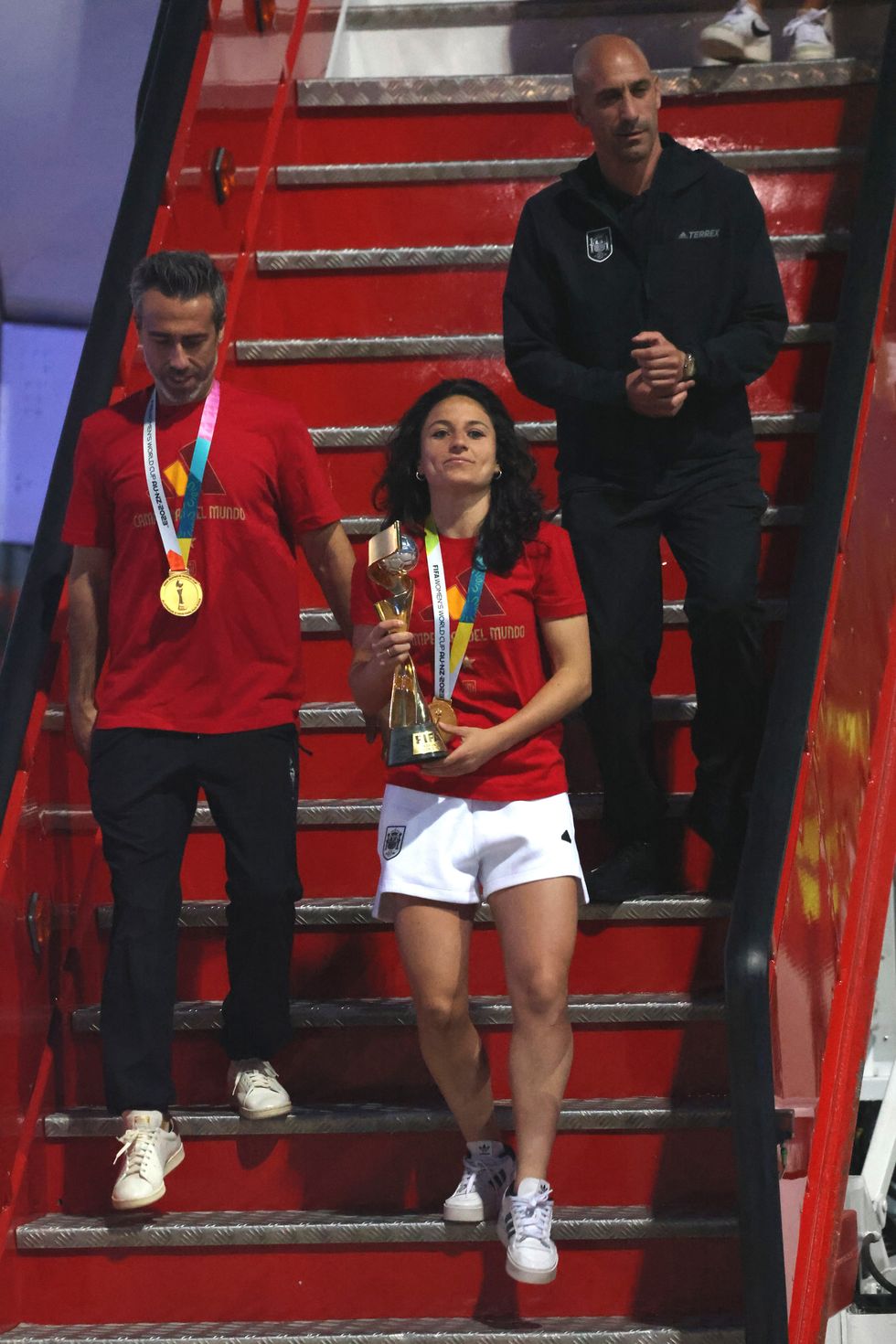 Ivana Andres decends the airplane stairs with the Spanish national teams trophy, followed by Jorge Vilda and Luis Rubiales