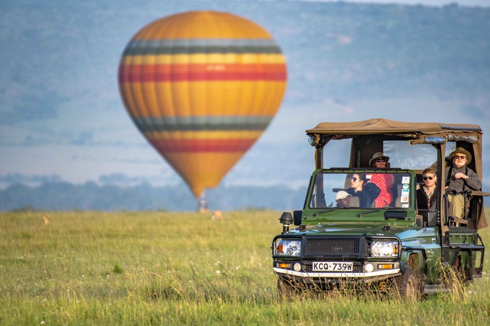 January 29, 2019, Talek, Kenya: A hot air balloon lands in the background as tourist drive by in a game viewer in Maasai Mara National Reserve, Kenya (Credit Image: © Edwin Remsberg / Vwpics/VW Pics via ZUMA Wire)
