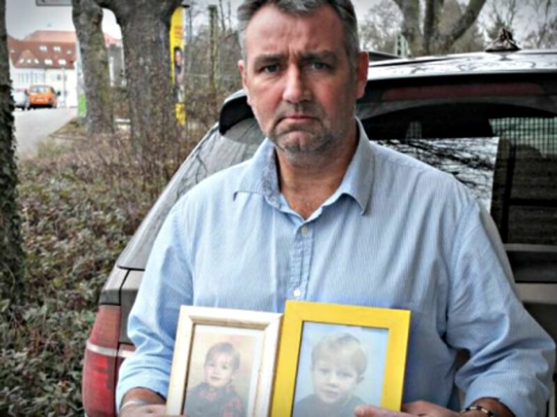Joachim Gerhard carrying pictures of his two sons