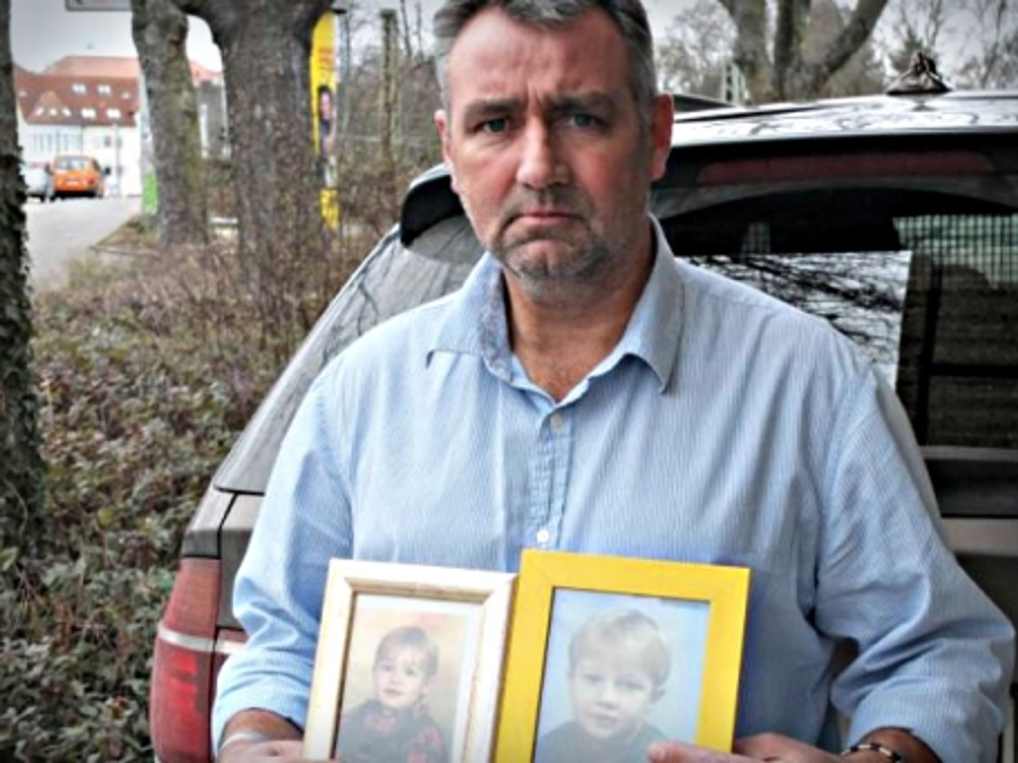 Joachim Gerhard carrying pictures of his two sons
