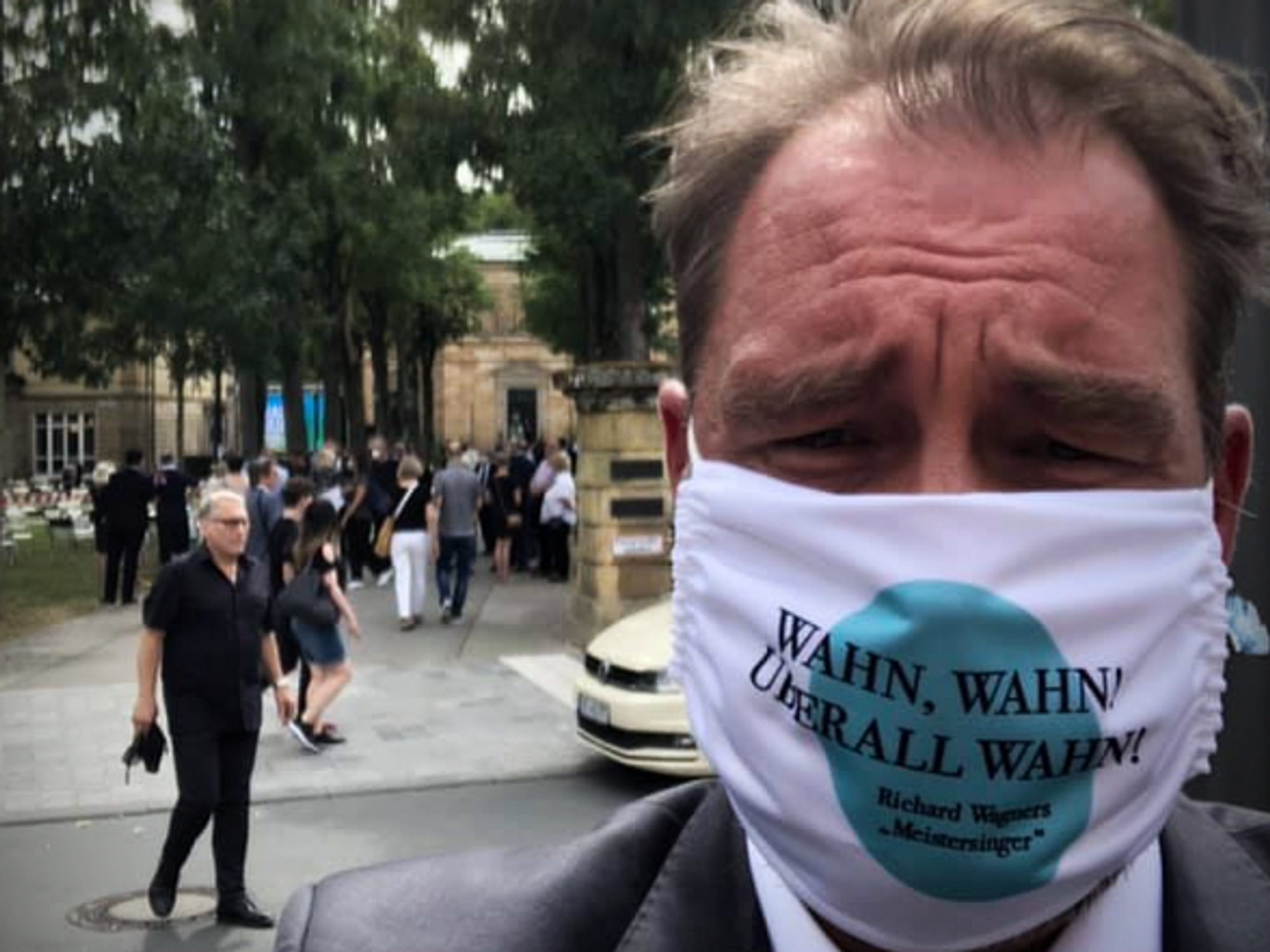 Journalist Peter Huth wearing a mask that says 'Madness, Madness! Madness everywhere!'