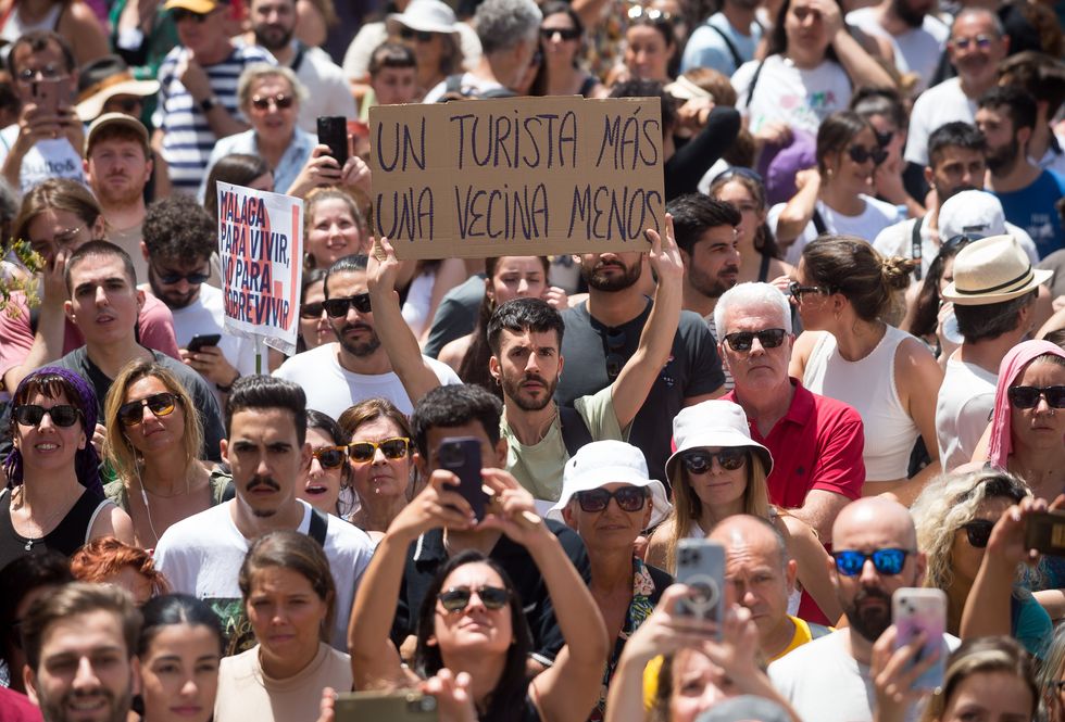 June 29, 2024, Malaga, Spain: A protester is seen holding up a placard expressing his opinion during a demonstration against mass tourism in the city, following recent protests in the Canary and Balearic islands or Majorca. Thousands of people took to the streets in the centre of Malaga to protest against the rising rental prices and to demand a decent housing. Over the past few years, the city of Malaga has experienced a significant housing crisis, largely due to rent speculation and a process of gentrification, which has made it difficult for many to access decent housing. Local neighbourhood associations and organisations are calling for measures to be introduced to limit rental prices and the impact of mass tourism. (Credit Image: © Jesus Merida/SOPA Images via ZUMA Press Wire)