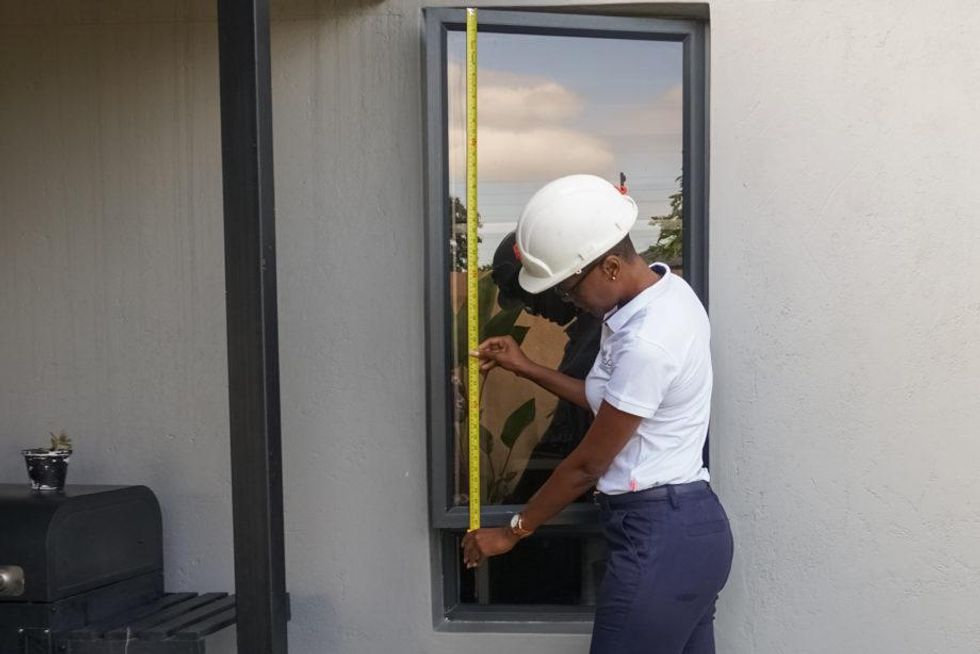 Kuda Hove measures a window for a house renovation project in Victoria Falls.