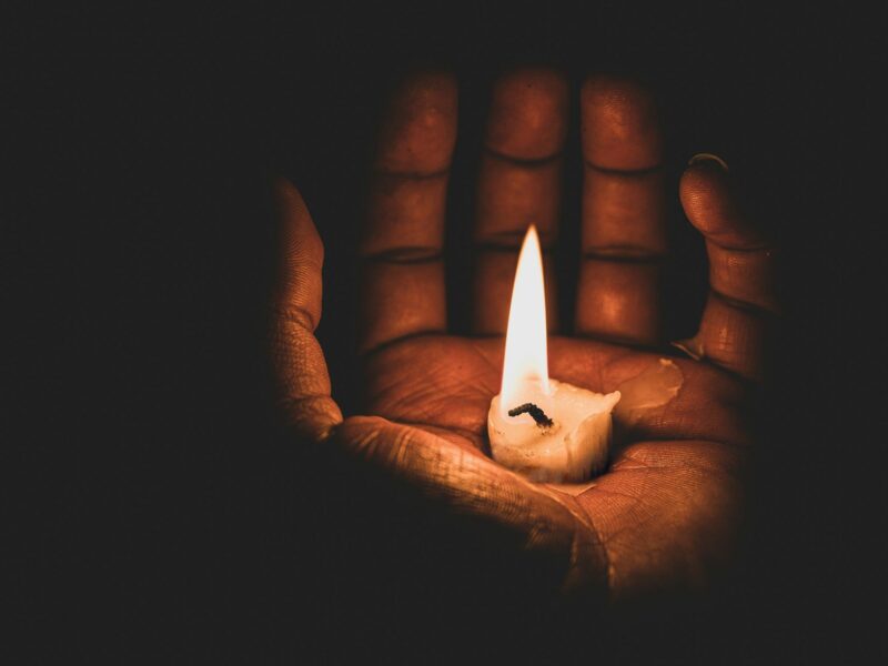 lit candle in hand