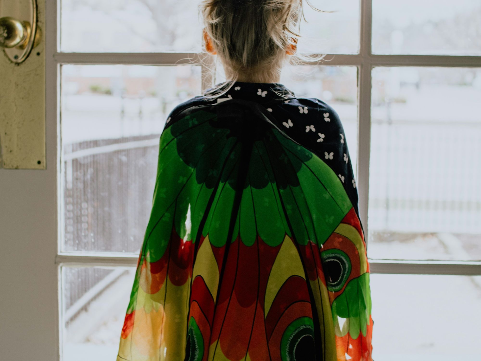 Little girl looking outside through door and window panes