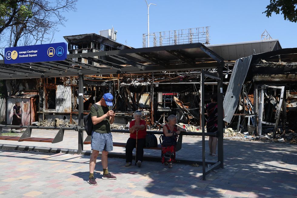 Local residents are seen at a bus stop in the city of Mariupol.