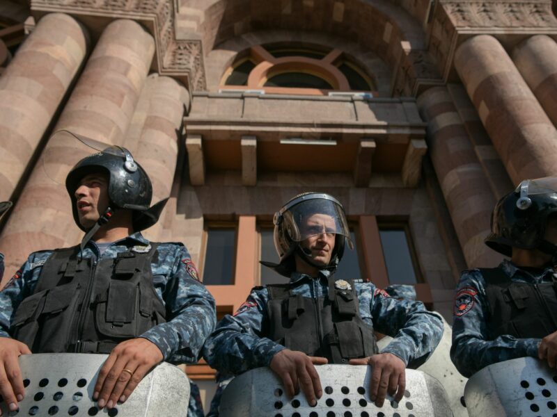 Low-angle shot of three police officers standing in front of the Armenian Government Building in Yerevan on Sept. 19