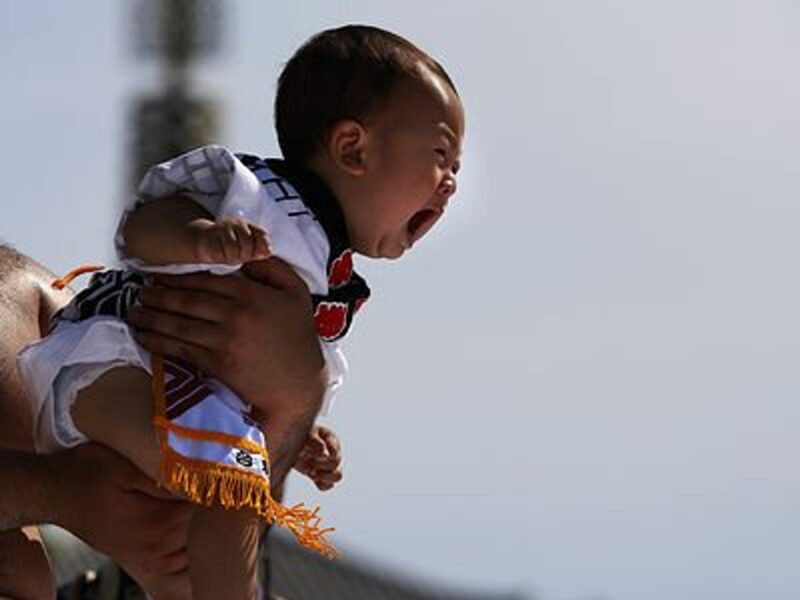 Man holding a baby crying.