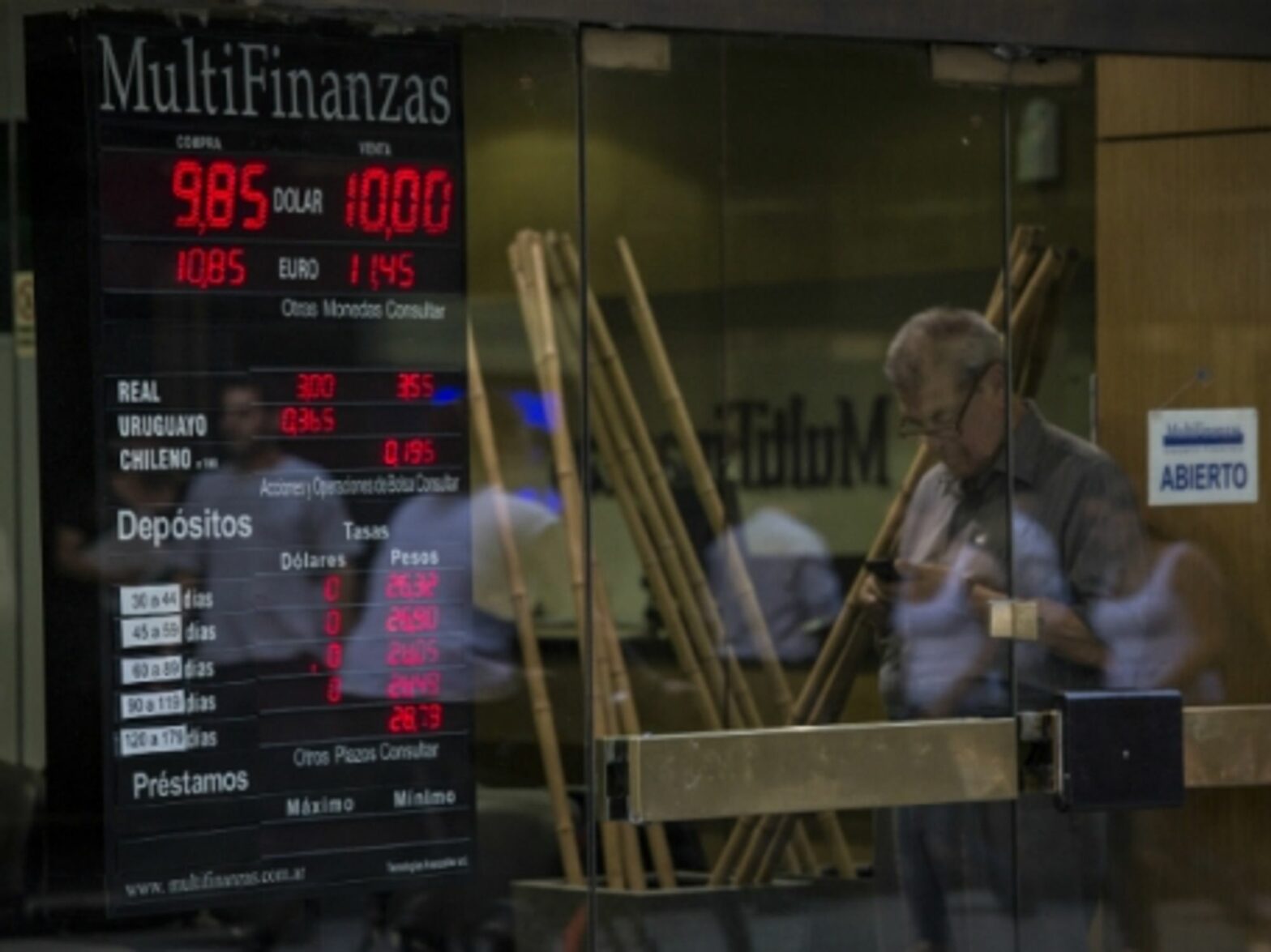 Man in front of a house of currency exchange in Buenos Aires.