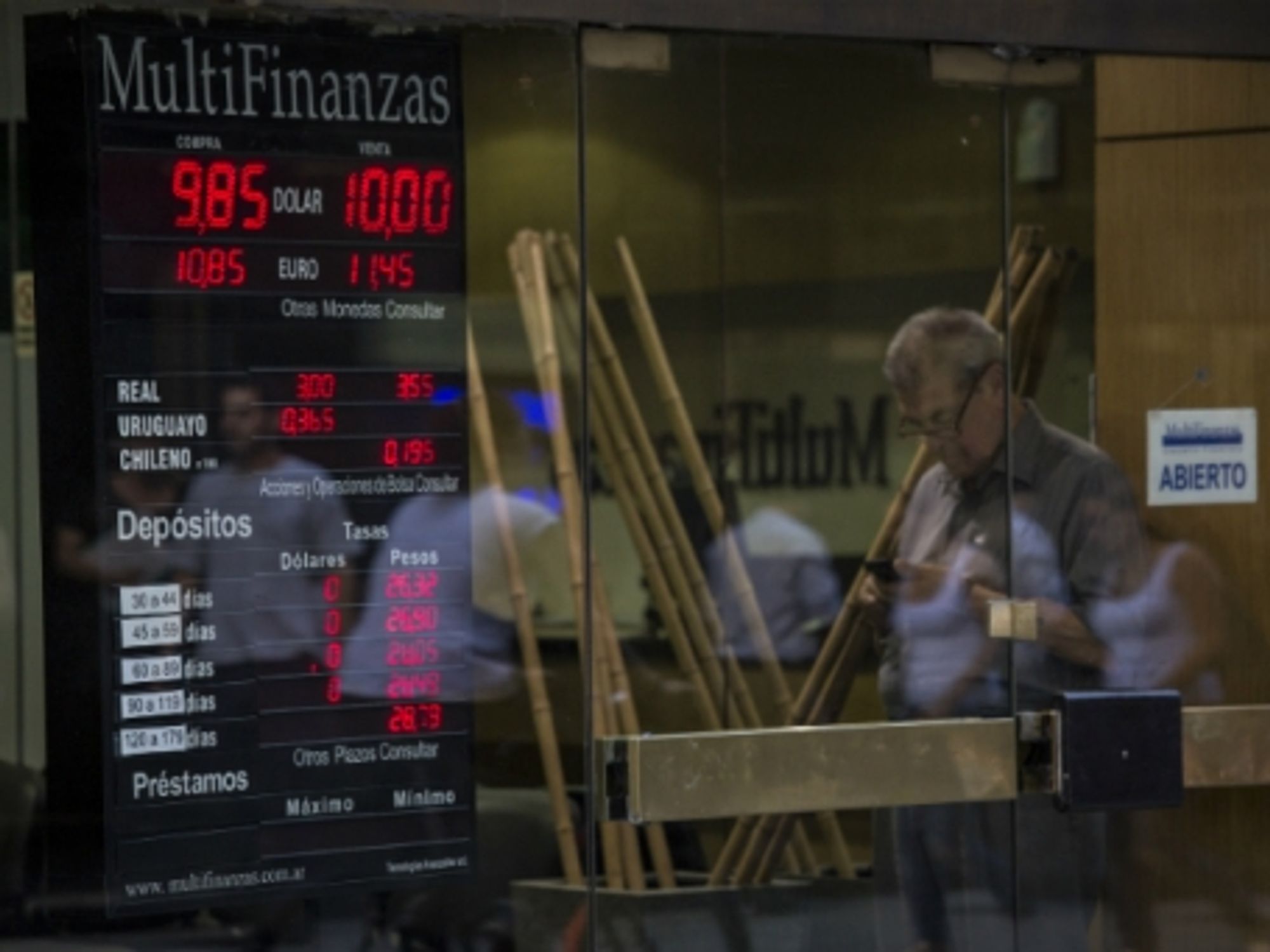 Man in front of a house of currency exchange in Buenos Aires.