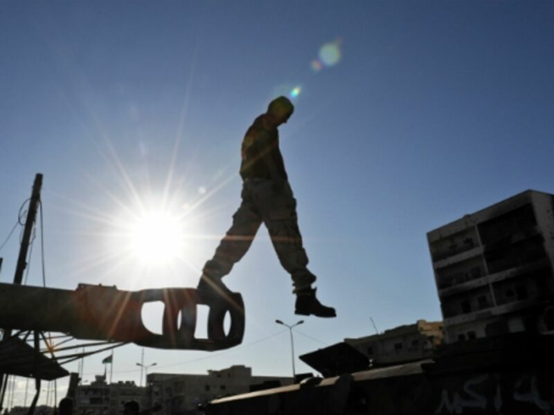 Man jumping off a disused military vehicle in Misrata, Libya