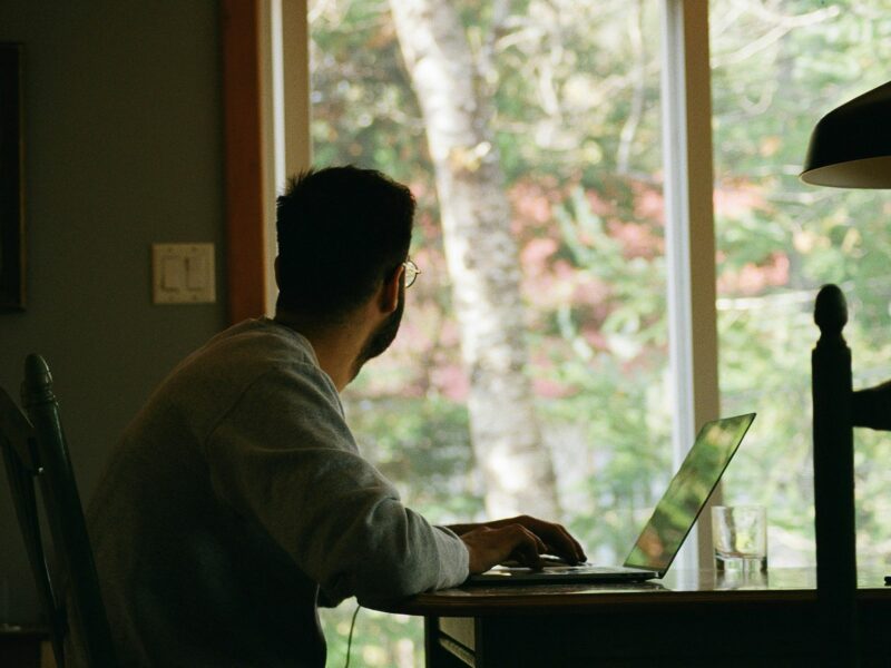 Man looking out the window while working from home.