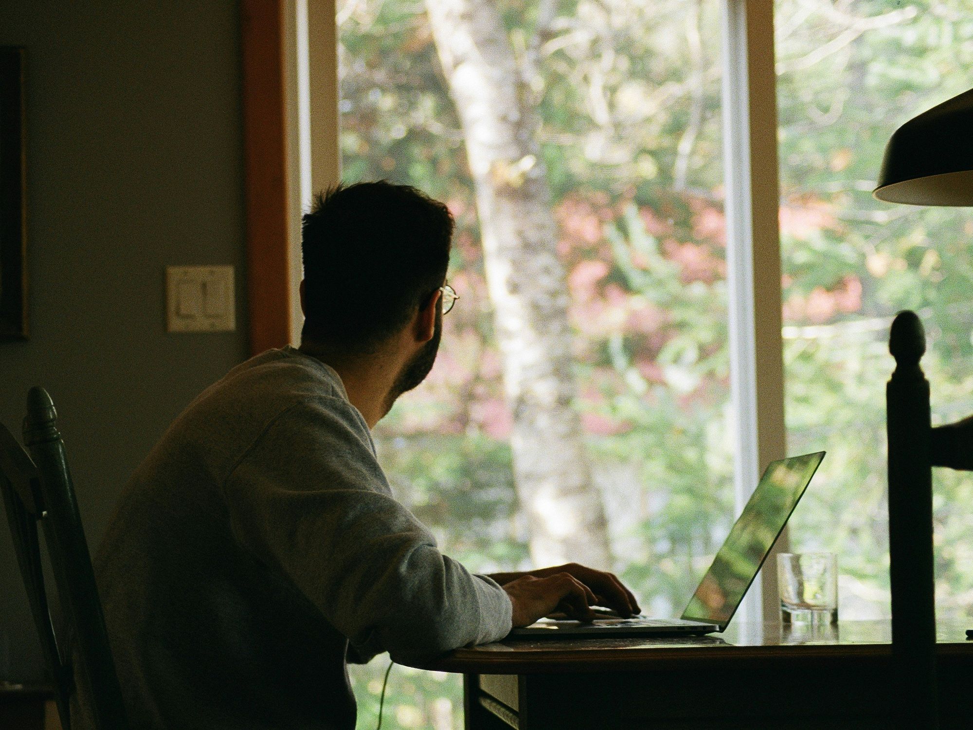 Man looking out the window while working from home.