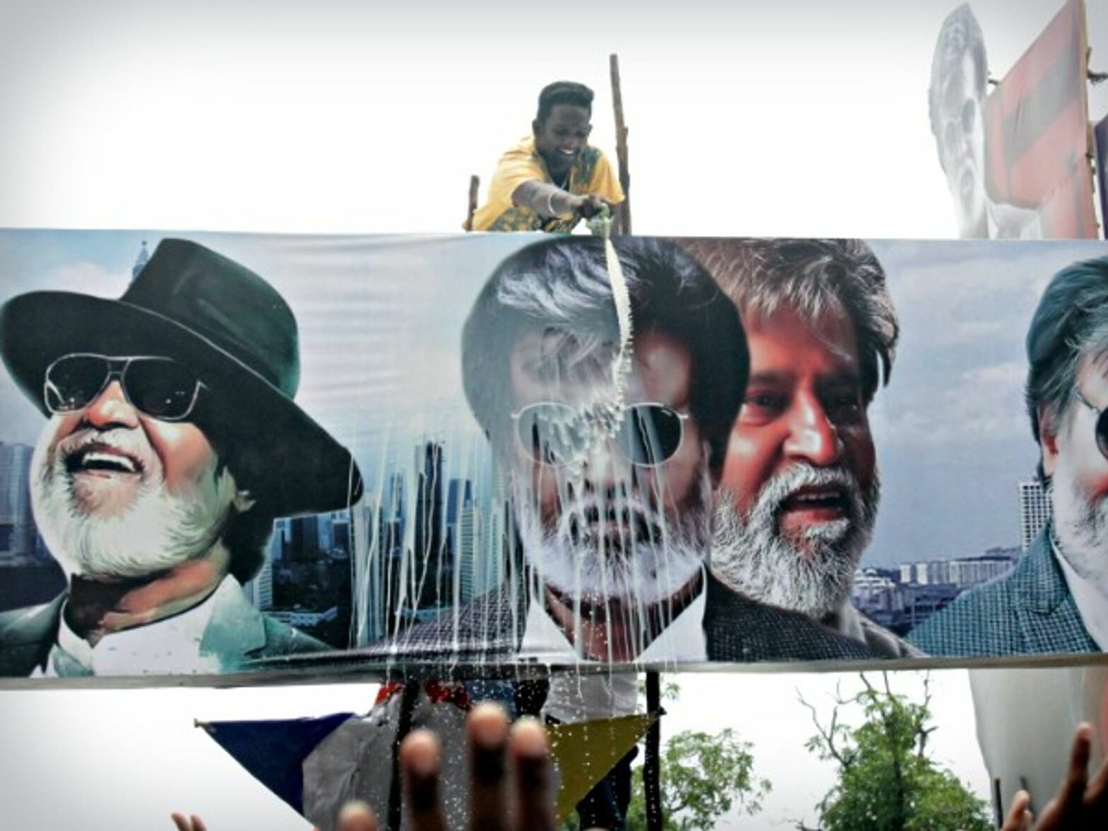 Man ritually pouring milk on a Rajinikanth poster in Chennai on July 22