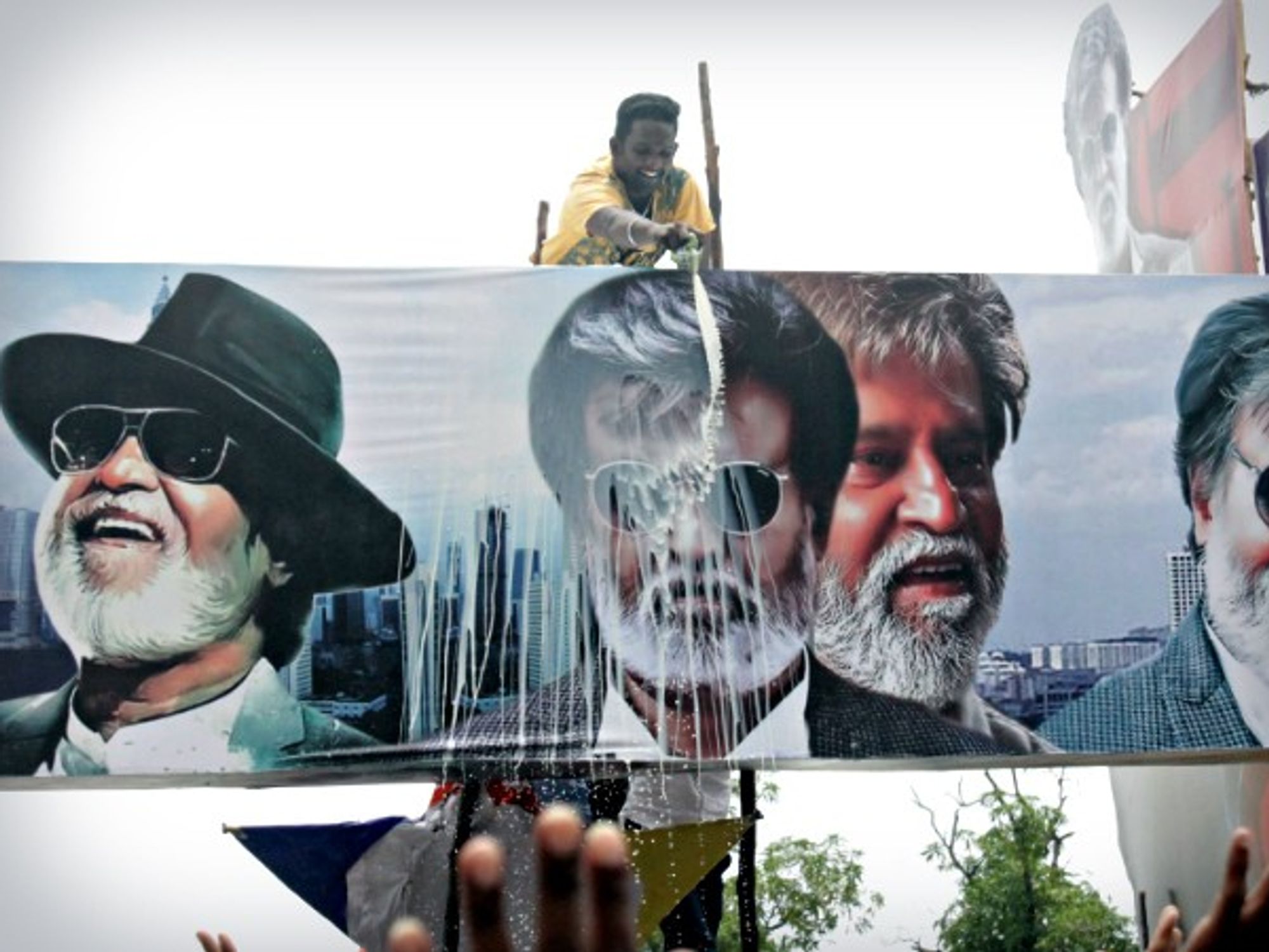 Man ritually pouring milk on a Rajinikanth poster in Chennai on July 22
