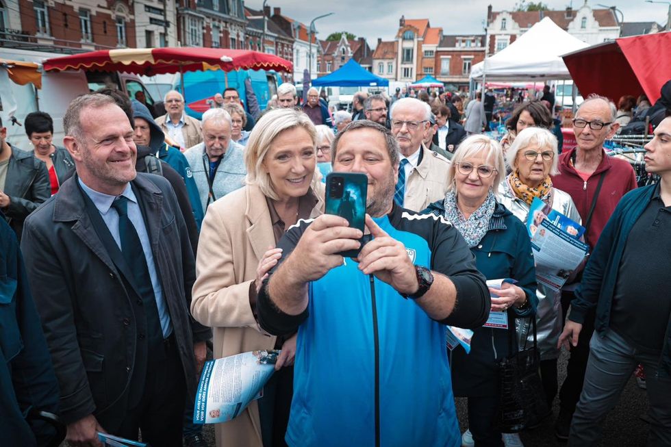 Marine Le Pen posing for selfies with supporters.