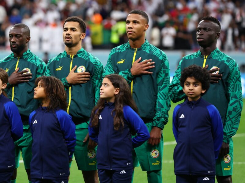Members of the Senegal football team sing their national anthem with hands over their hearts