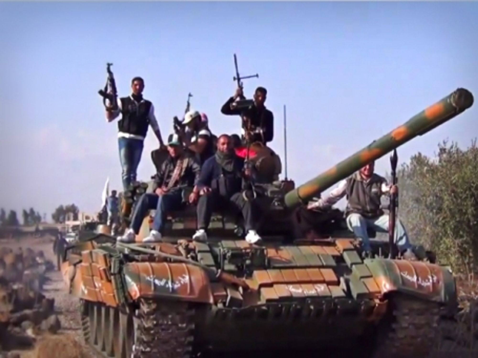 Members of the Yarmouk Martyrs Brigade parading on a tank