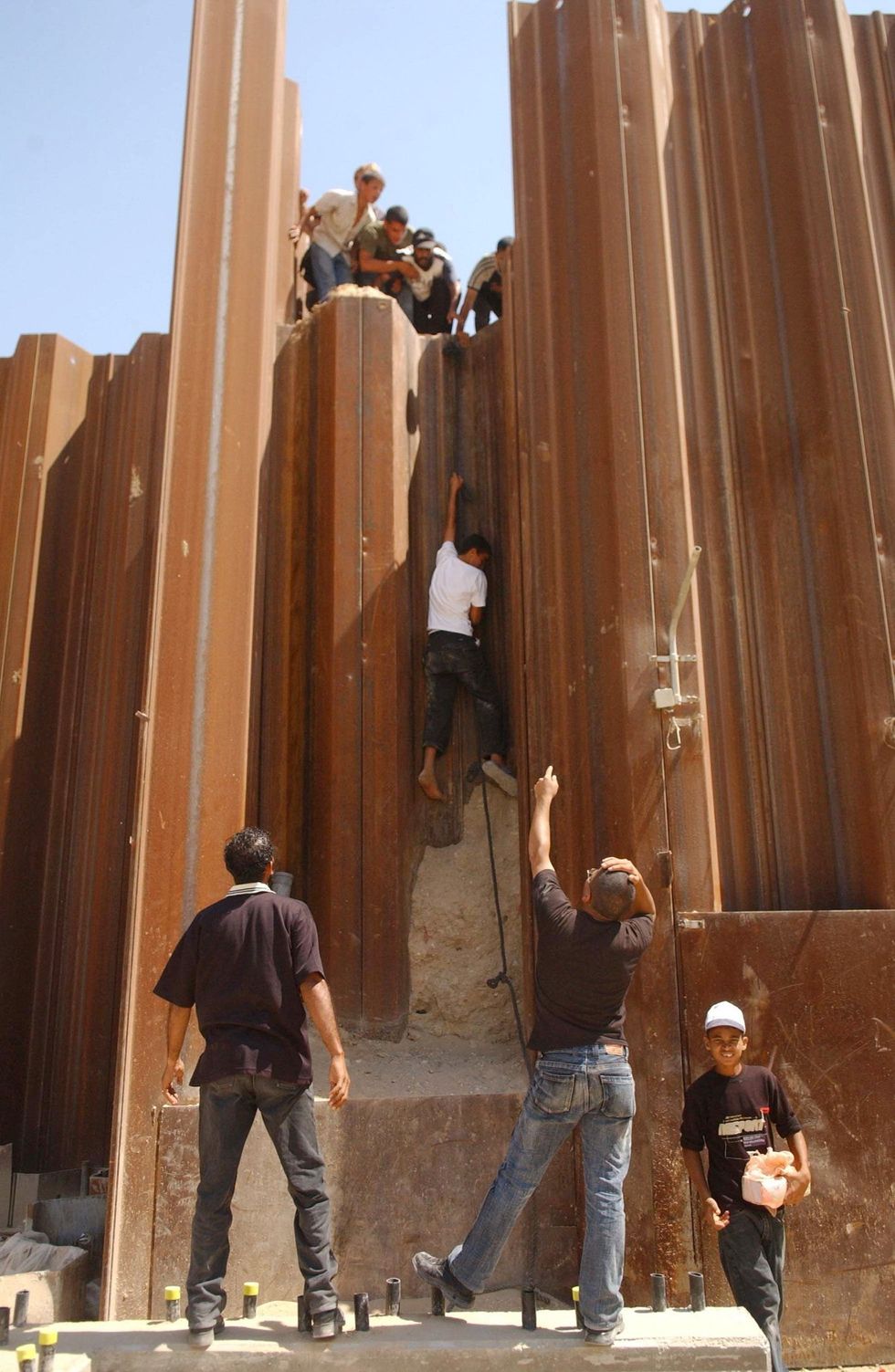 Men climbing the Philadelphi Corridor from the wall that seperated Gaza from Egypt