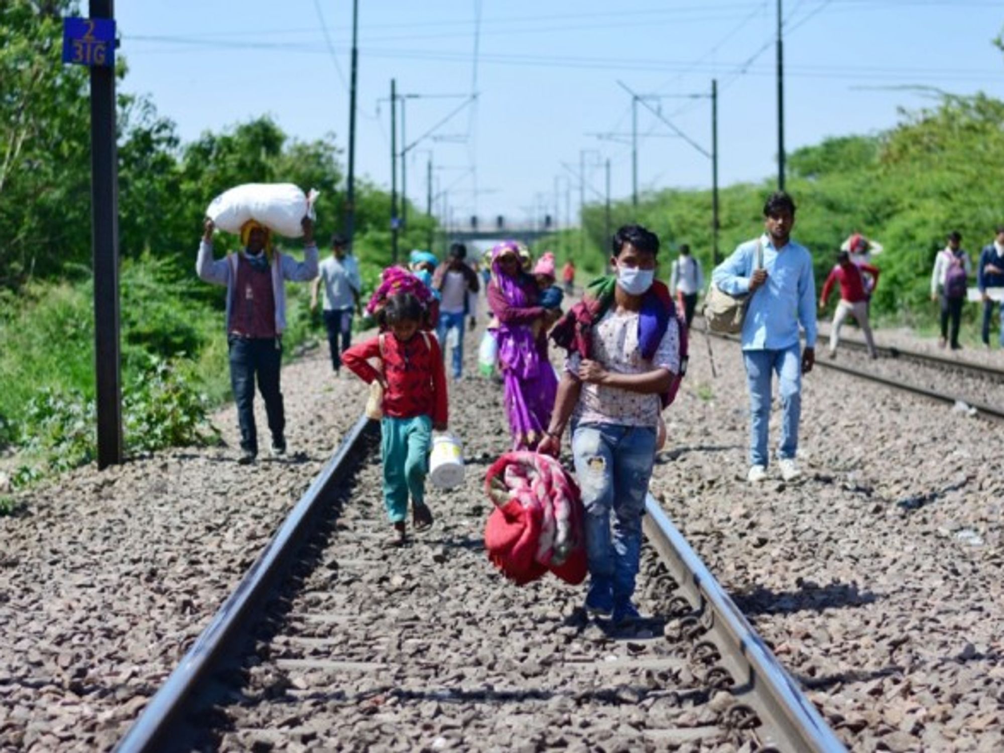 Migrant workers and their family members walking towards Laxmi nagar train station leaving India's capital for their villages, during the nationwide lock down.