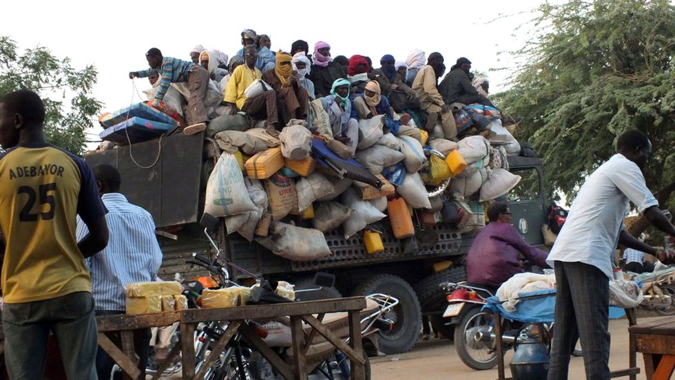 Migrants sit on top of a truck that is about to leave the city of Agadez in Niger, 27 April 2015
