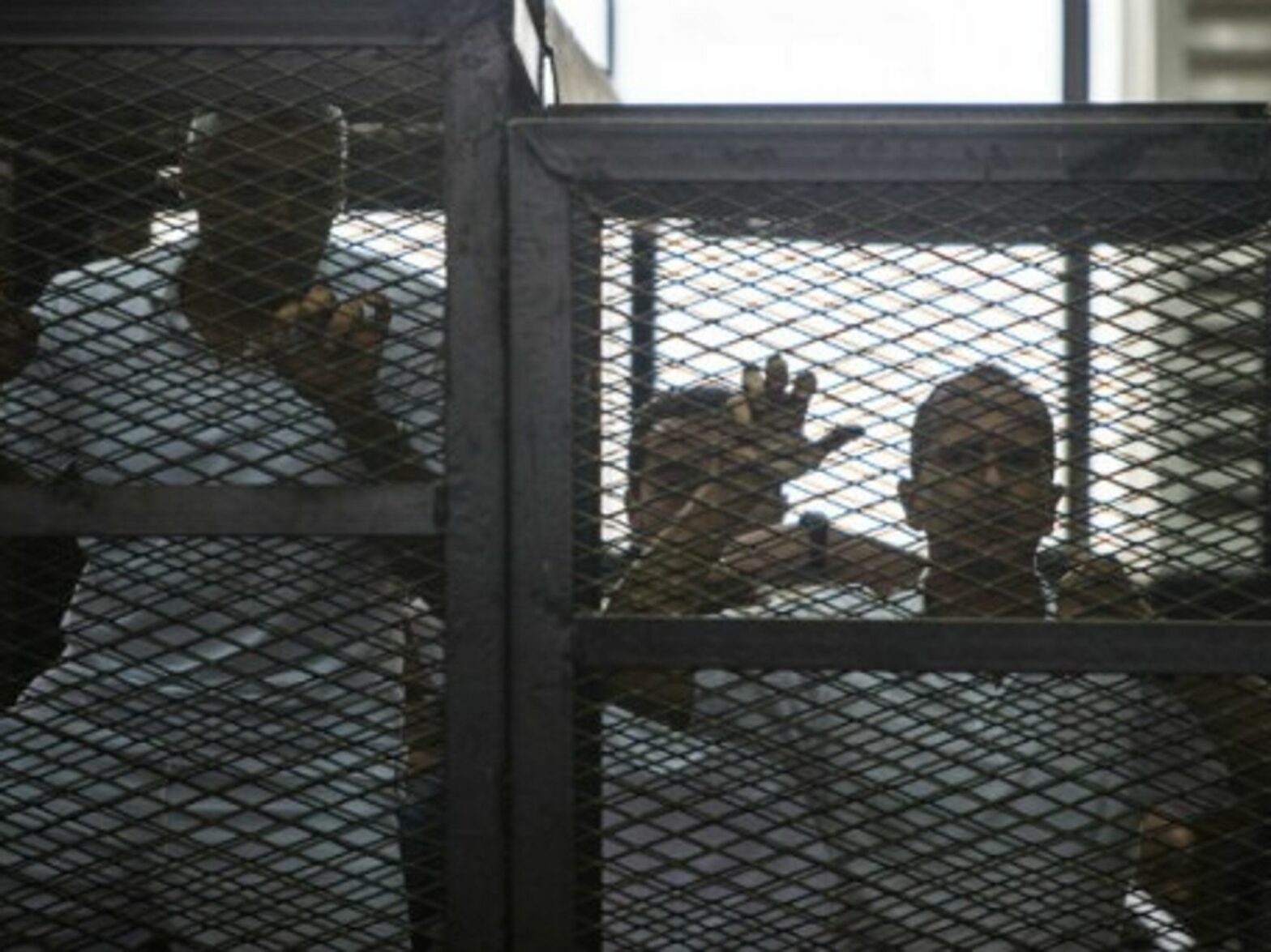 Mohamed Fadel Fahmy and Peter Greste listen to the verdict at a court in Cairo, June 23, 2014.