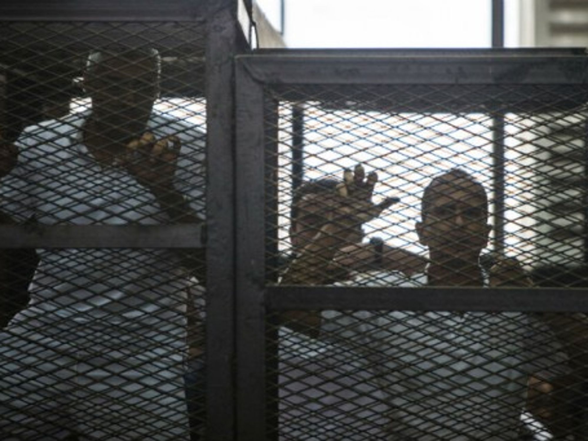 Mohamed Fadel Fahmy and Peter Greste listen to the verdict at a court in Cairo, June 23, 2014.