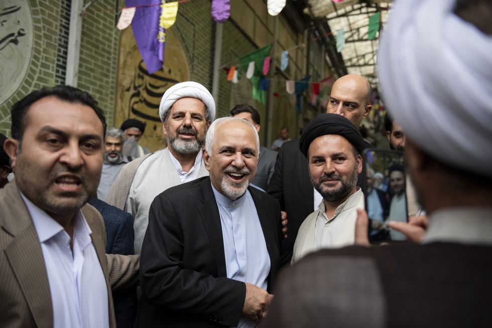 Mohammad Zarif smiles at the camera after a meeting in a busy street of Teheran.