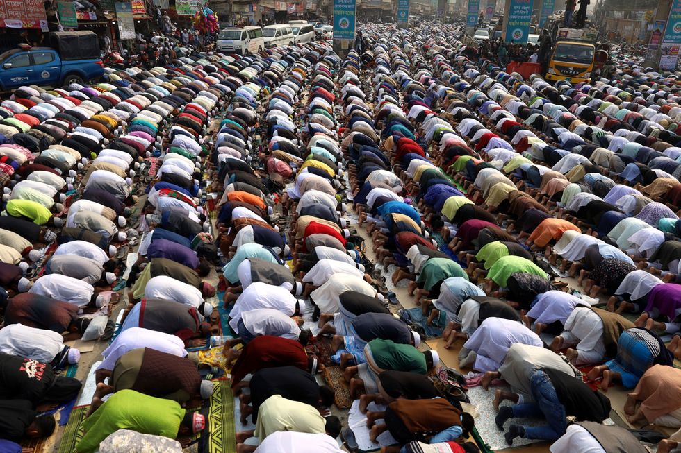 Muslim filling the streets of a city to pray.