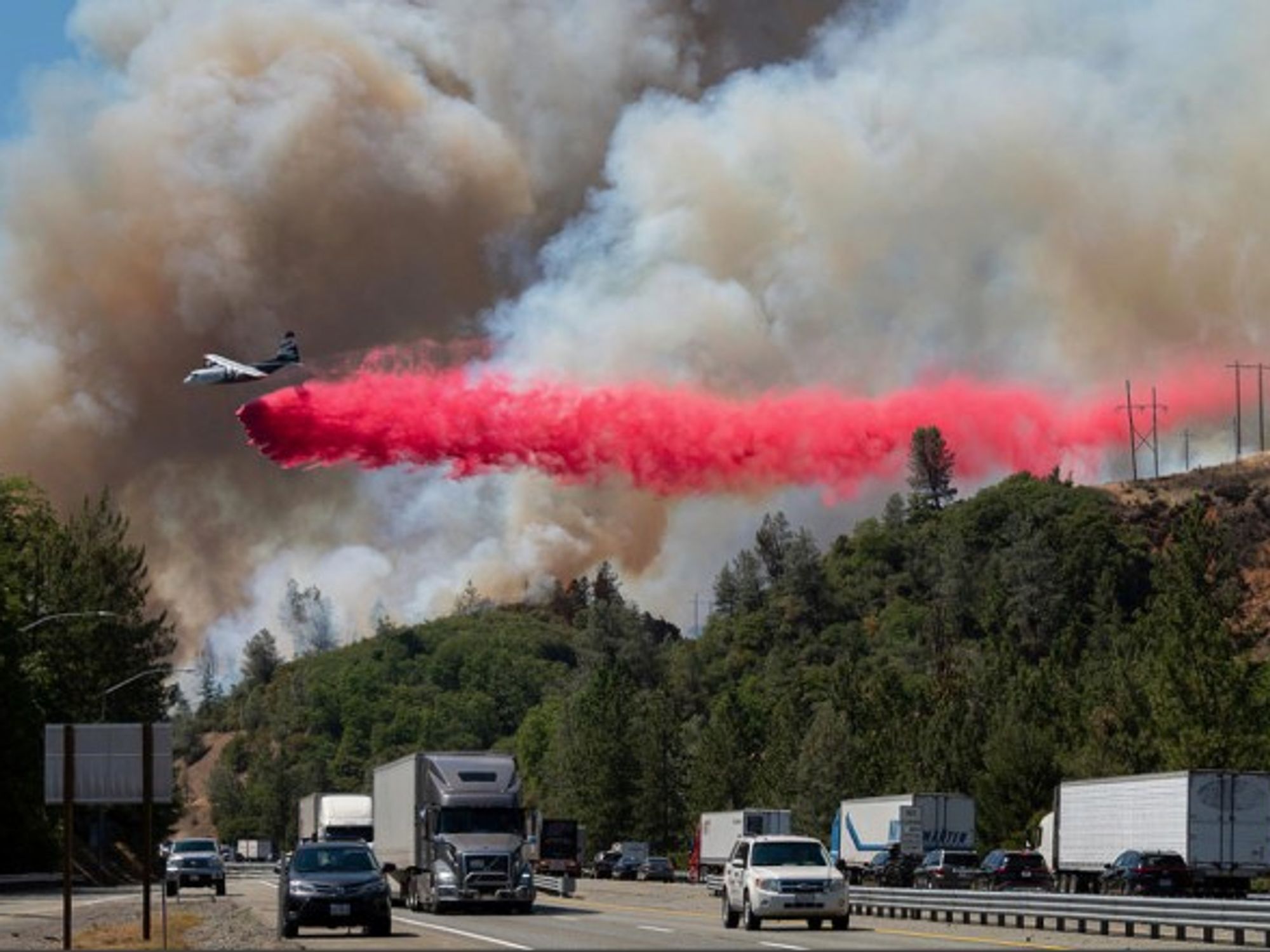 Near Lake Shasta, California, an air tanker releases fire retardant in an effort to extinguish the growing wildfire next to the northbound I-5 freeway. The U.S. Forest Service has ordered evacuations in the area.