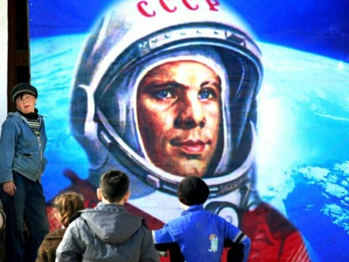 Near Russia's Baikonur cosmodromel, children examine an image of space pioneer Yuri Gargarin
