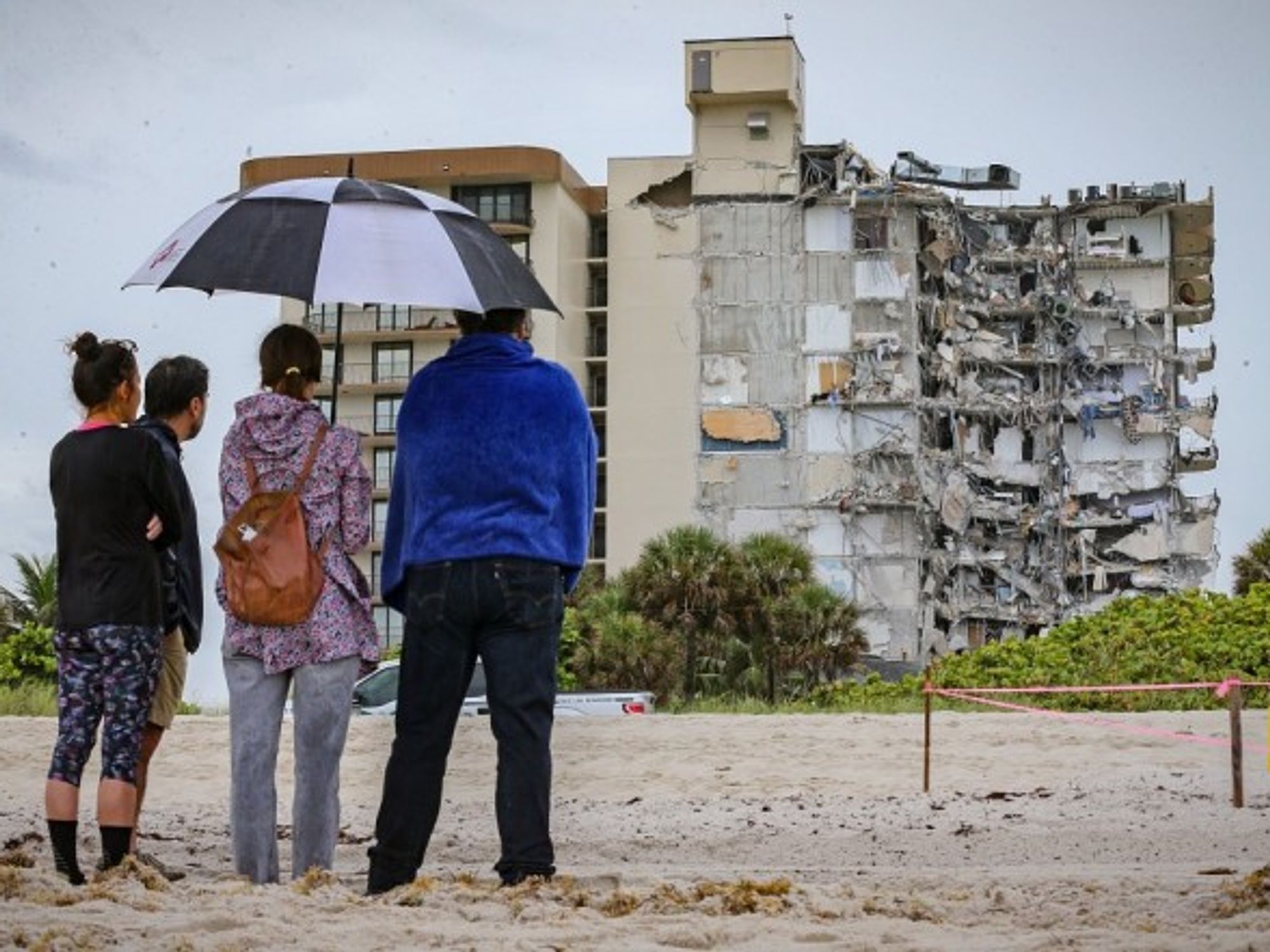 Neighbors look at rumble of a 12-story Miami building after its partial collapse