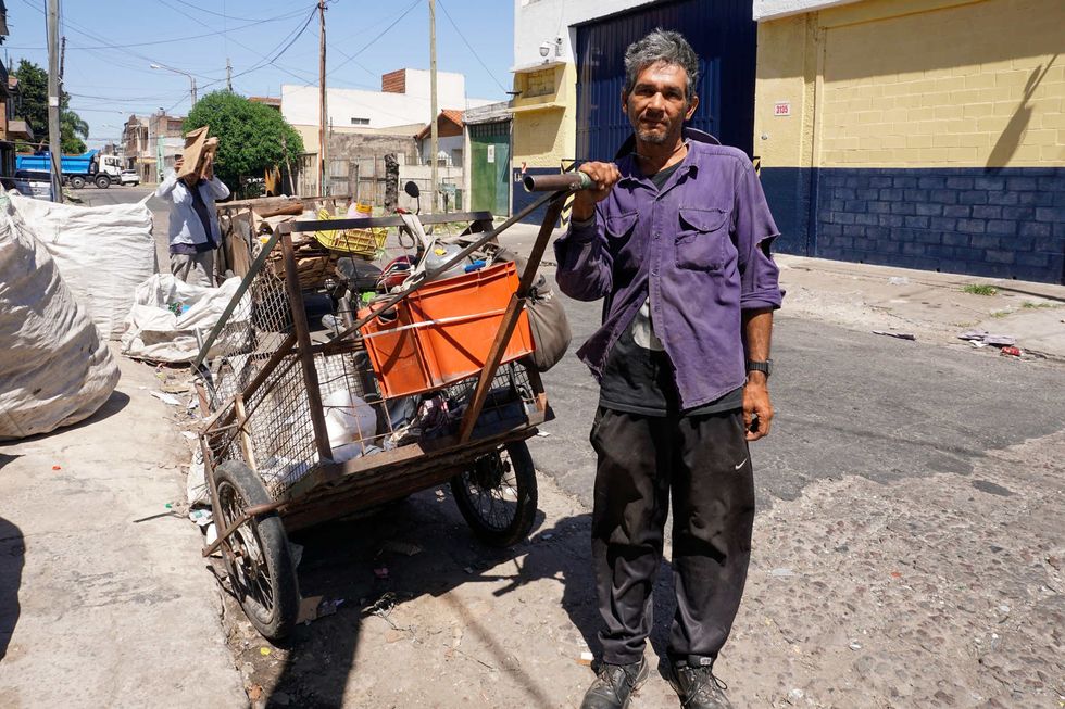 Nelson Villasboa poses next to the cart he used to collect recyclables on his last day as a waste-picker.