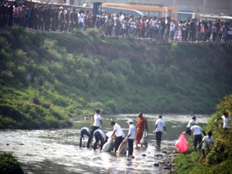 Nepalese people pick up rubbish on the Bagmati river on April 11, 2015.
