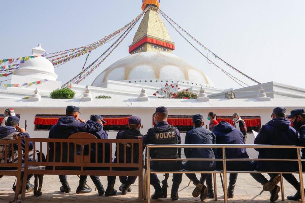 Nepalese police watch over a Tibetan celebration.