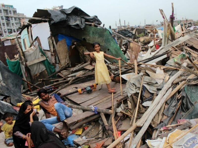 New Delhi residents outside demolished slum dwellings