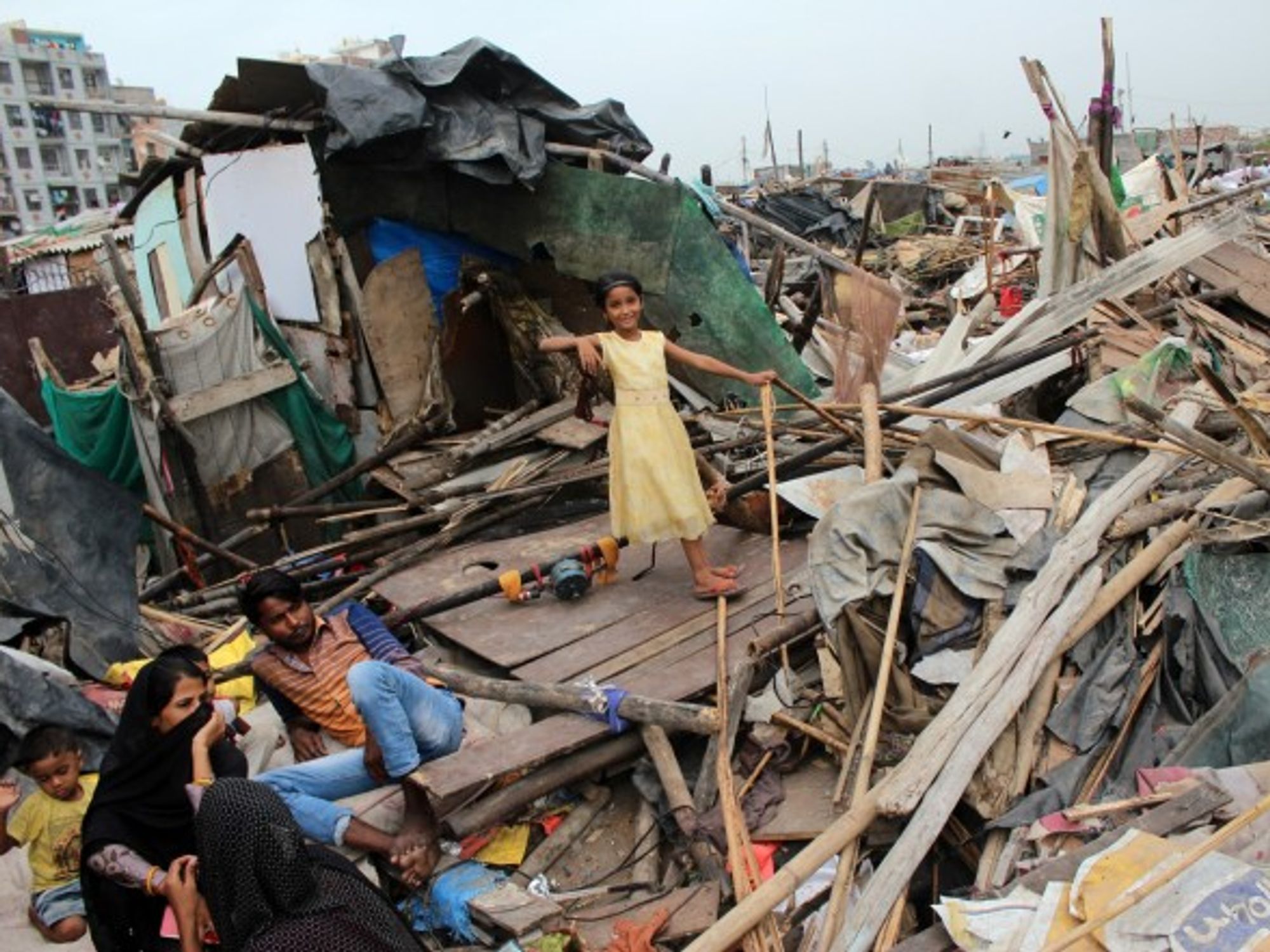 New Delhi residents outside demolished slum dwellings