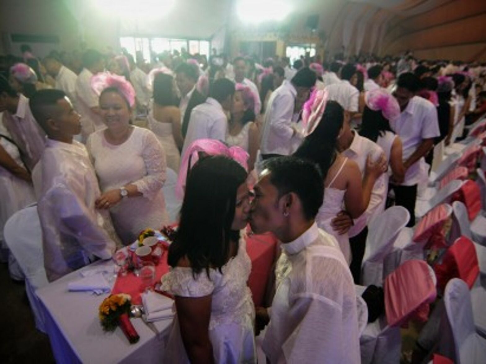 Newlywed couples kiss during a mass wedding ceremony in Manila on Valentine's Day.