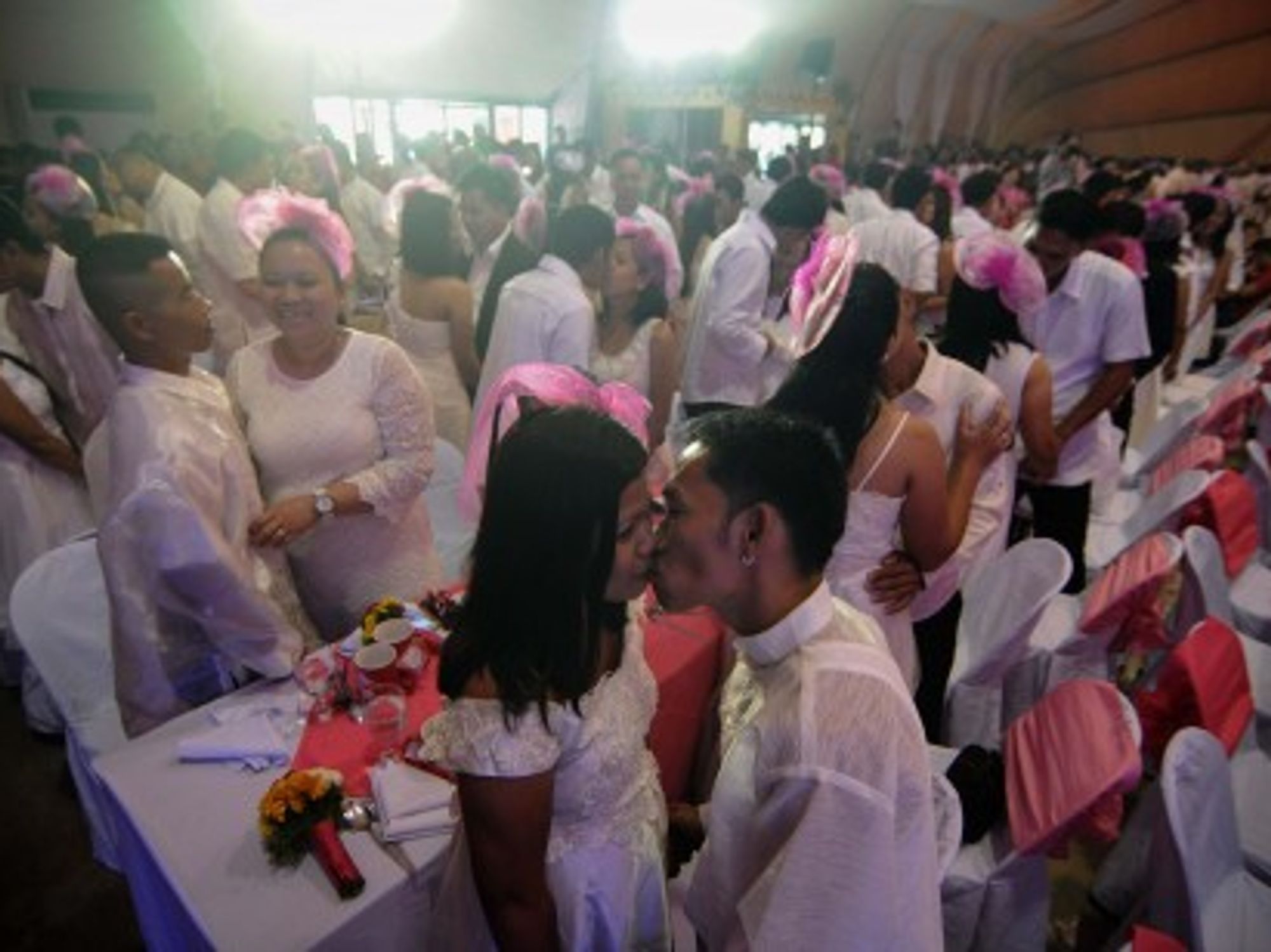 Newlywed couples kiss during a mass wedding ceremony in Manila on Valentine's Day.
