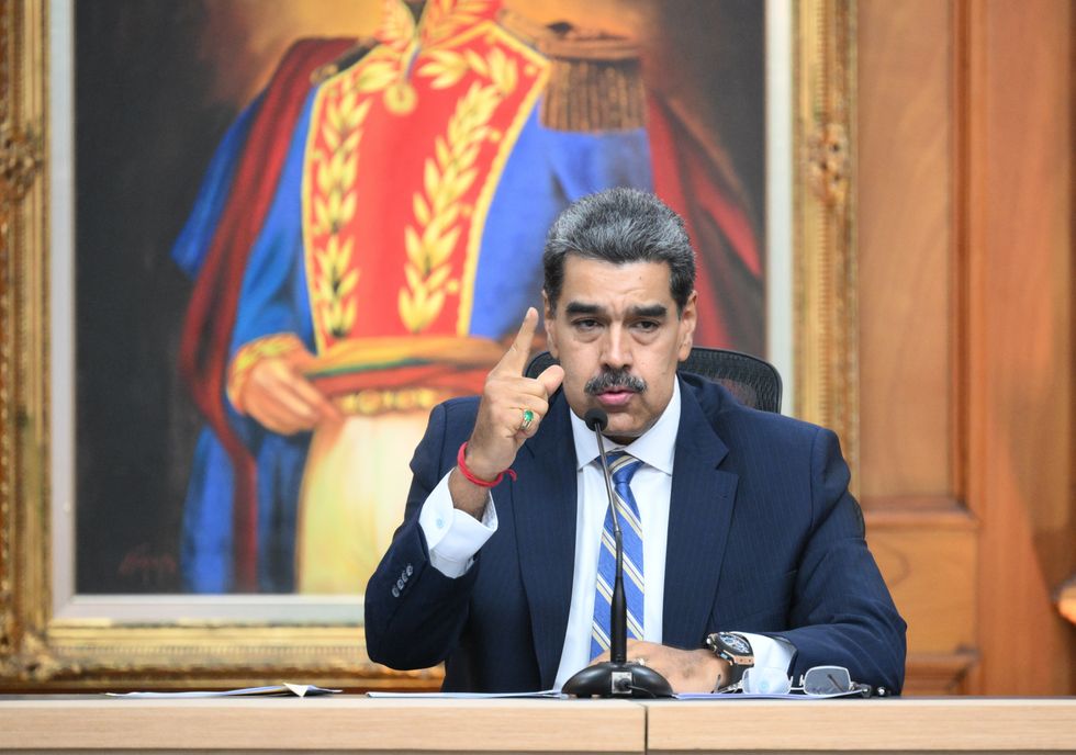 Nicolás Maduro gives a speech seated with a large painting behind him
