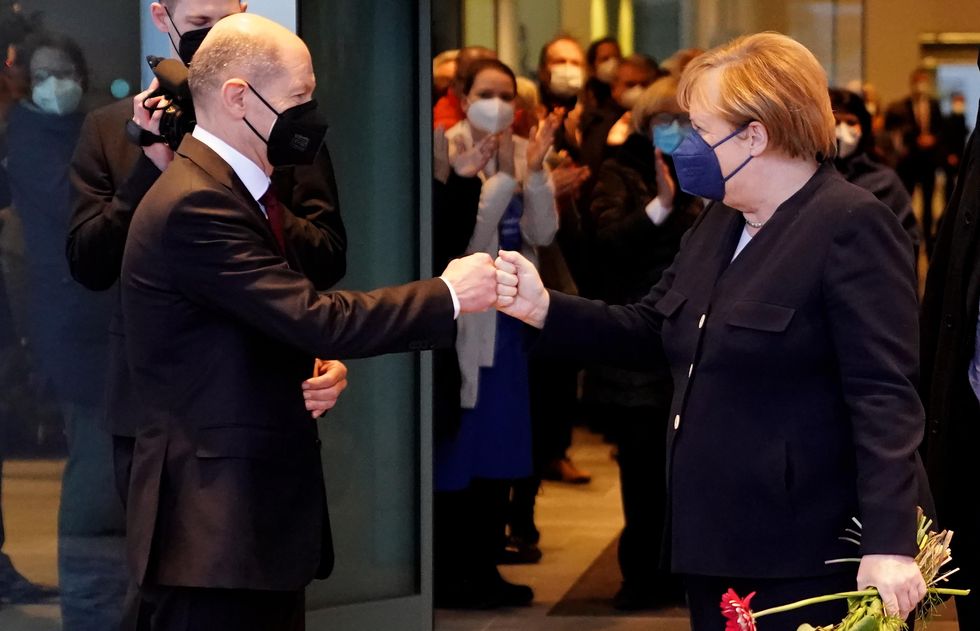 Olaf Scholz and Angela Merkel do a fish bump